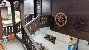 A wooden staircase with a railing, a wooden bench, and a wall with two wooden wheels. - Chalet Imfeld-Gander by Interhome (Bürglen OW)