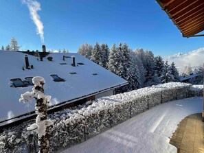 A snow-covered building with a sloped roof, surrounded by snow-laden trees and a clear sky. - Cosy Unterkunft in Crans-Montana in der Nähe von Espace Kids by Interhome (Crans-Montana)