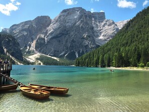 A clear lake with boats, a wooden dock, and mountains in the background. - Rosenheim Appartement 4 by Interhome (Meransen Maranza)