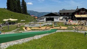 Ein Skigebiet mit Seilbahn, Outdoor-Fitnessbereich und einem Gebäude mit der Beschriftung 