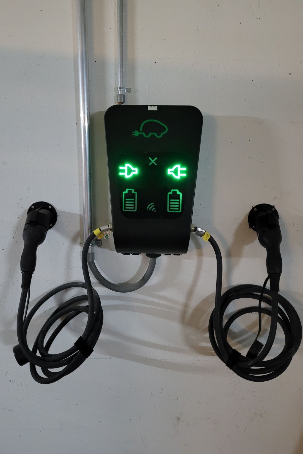 Estación de carga con dos conectores y una pantalla que muestra los niveles de batería.