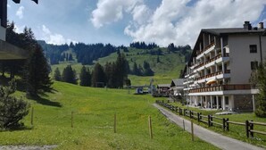 Un hôtel offrant une vue sur une vallée verdoyante et des montagnes.