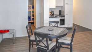 Un espace de vie compact comprenant un coin repas, une kitchenette et un petit espace nuit.