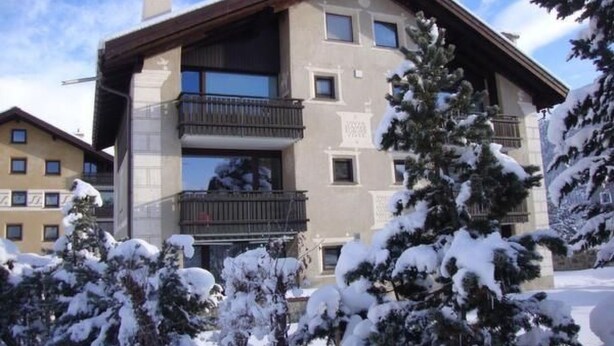 A multi-story building with balconies, surrounded by snow-covered trees. - Chesa Arettas by Interhome (Bever)
