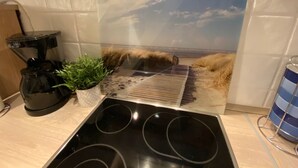 Une cuisine équipée d’une cuisinière, d’une machine à café et d’une plante en pot.