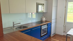 Une cuisine moderne avec un plan de travail en bois, un évier en acier inoxydable et des armoires bleues.