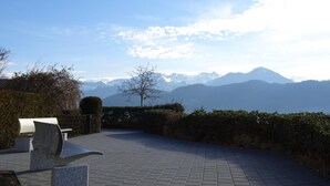 A paved outdoor area with a bench and a sculpture, overlooking a mountain range. - Wohnung mit herrlichem Blick auf den Pilatus by Interhome (Weggis)