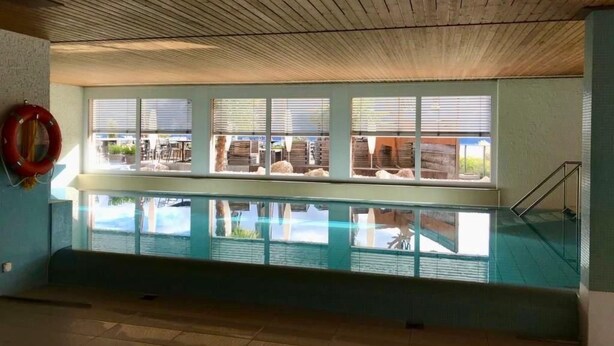 A pool area with a view of the beach, wooden ceiling, and a lifebuoy on the wall. - Wohnung mit herrlichem Blick auf den Pilatus by Interhome (Weggis)
