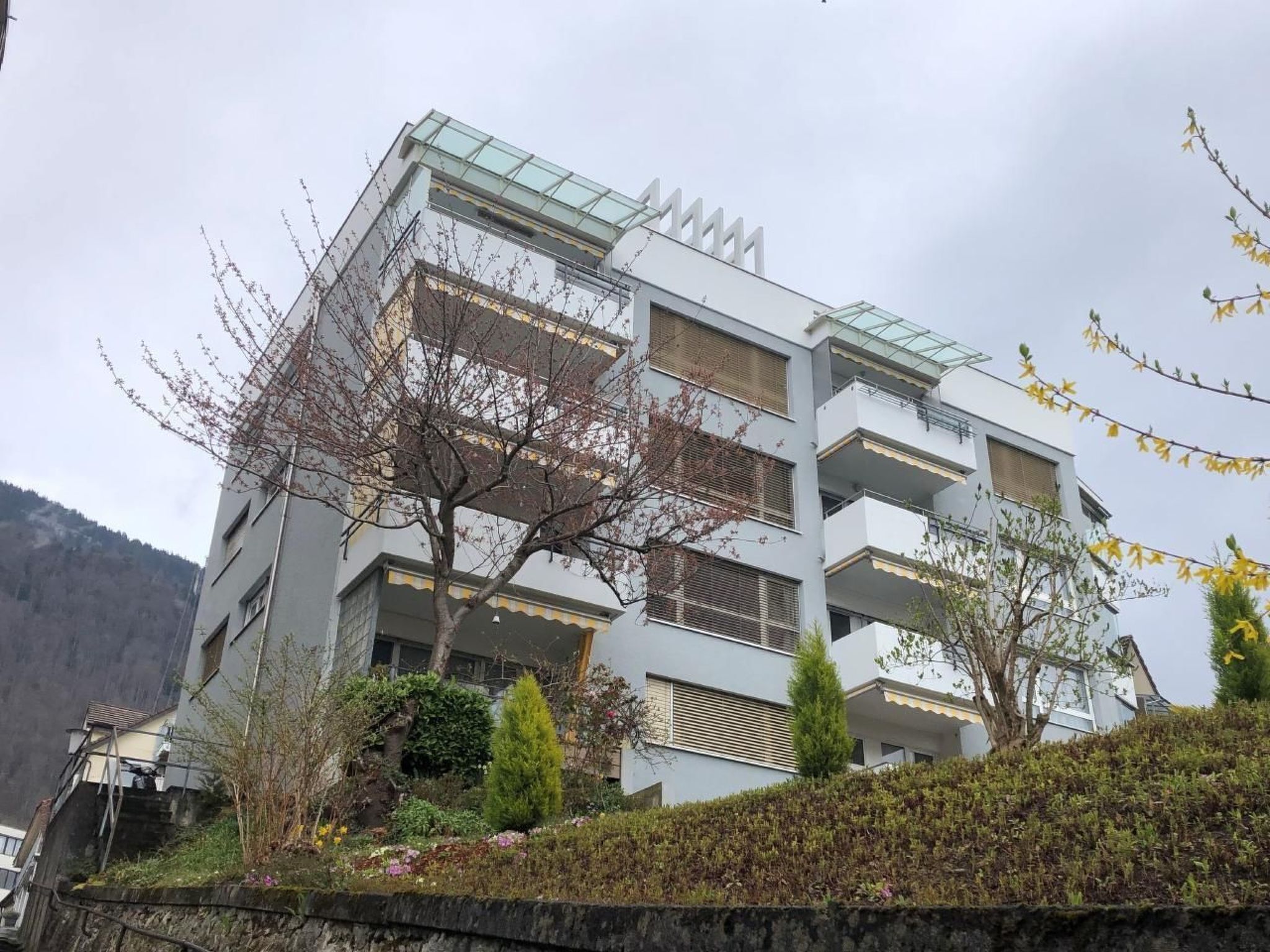 Un immeuble à plusieurs étages doté d’une architecture moderne, avec des balcons et une façade en verre.