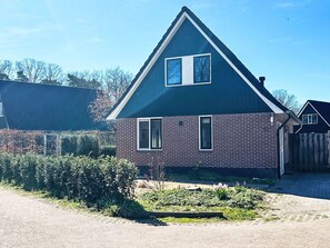 A two-story house with a brick facade and a gabled roof.