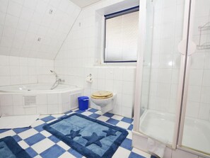 Un bany amb banyera, vàter i plat de dutxa.