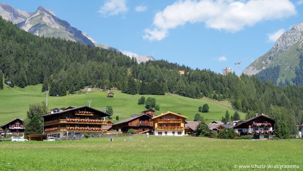 A mountain lodge with multiple floors, outdoor seating, and a view of the surrounding mountains. - Osttirol by Interhome (Kals am Großglockner)