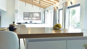 A modern kitchen with wooden beams, a large window, and a fruit bowl on the counter. - La Finca OliveTree by Interhome (Katuni)