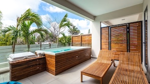 Eine moderne Terrassengrundstück mit Pool, Holzmöbeln und Blick auf Palmen.