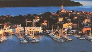 A coastal town with a marina filled with boats, a prominent lighthouse, and a hill in the background. - Gemütliche Ferienwohnung Emil by Interhome (Dragišina)
