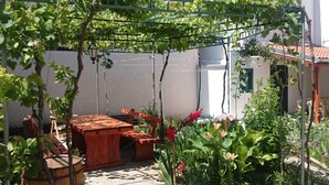 A garden with a pergola, wooden furniture, and a barrel. - Gemütliche Ferienwohnung Emil by Interhome (Dragišina)