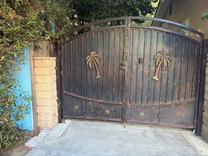 A gated entrance with a curved top, featuring palm tree-shaped handles. - Cozy 1-bedroom studio in charming Los Angeles with AC (Los Angeles)