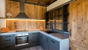 Una cocina moderna con armarios de madera, horno empotrado y pileta de acero inoxidable.