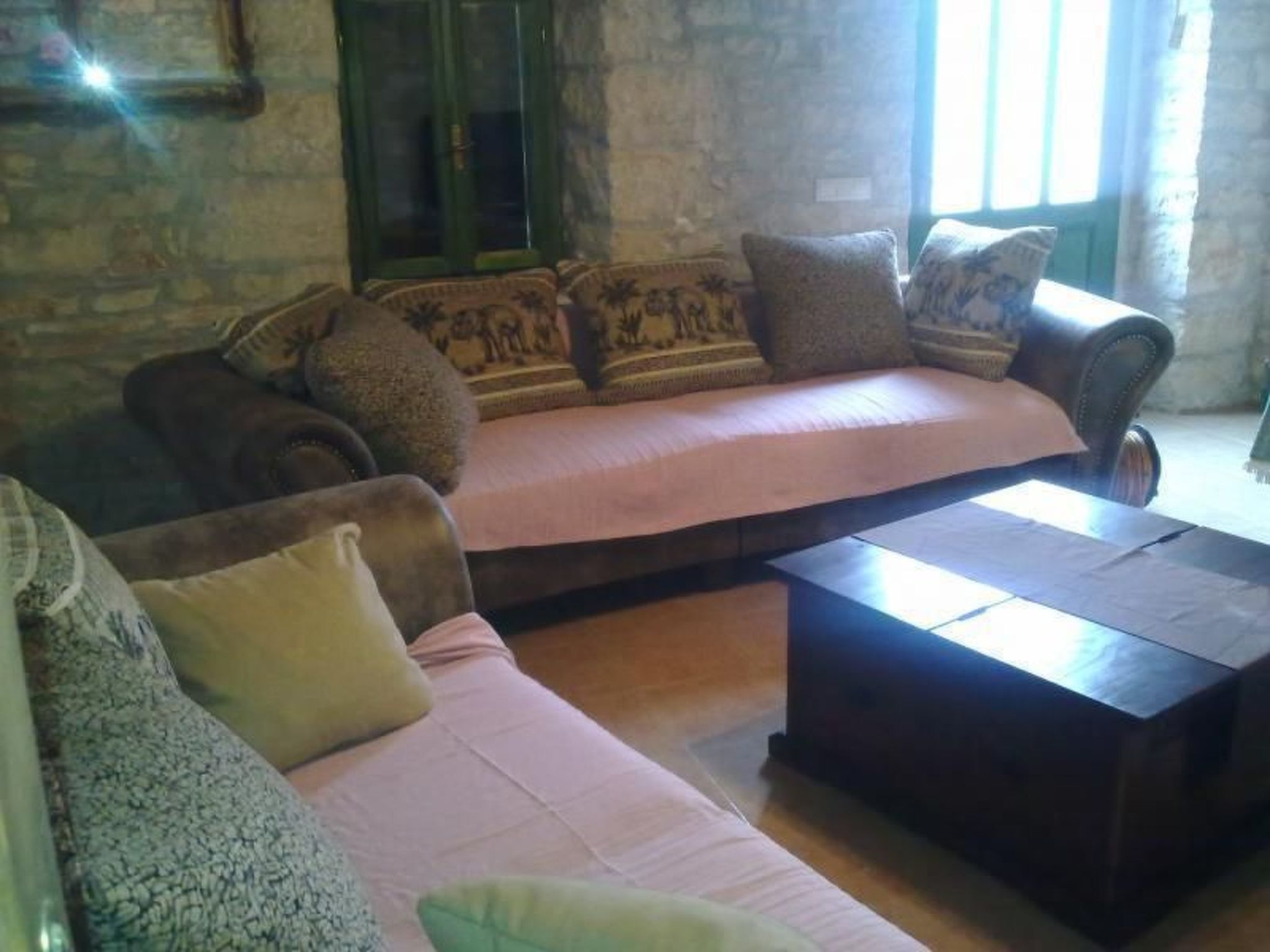 A cozy living room with a sofa set, a coffee table, and a patterned rug.