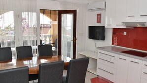Et moderne køkken med hvide skabe, et rødt backsplash og en indbygget ovn.