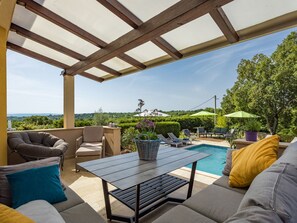 A covered outdoor seating area with a pool, lounge chairs, and a view of the landscape. - Villa Krase mit Pool by Interhome (Pula/Rakalj)