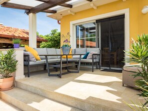A covered patio with a sofa, a table, and potted plants. - Villa Krase mit Pool by Interhome (Pula/Rakalj)