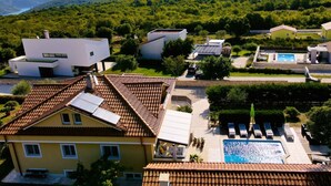 Un barrio residencial con casas modernas, una piscina y vistas a las montañas.