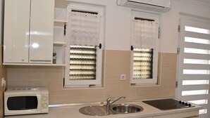 A kitchen with a microwave, sink, and cabinets.