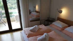 Ein Hotelzimmer mit einem Bett, einem Sessel, einem Tisch und Blick ins Freie.