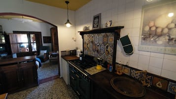 Een koelkast, een magnetron, een oven, kookgerei, borden en bestek