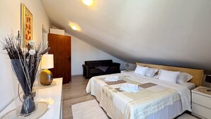 A bedroom with a large bed, two bedside tables, a nightstand, a wooden door, a wall-mounted lamp, and a decorative vase with branches. - Apartment Lure by Interhome (Polje)