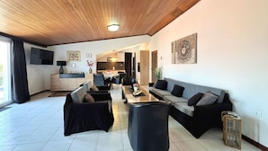 A modern living room with a wooden ceiling, a dining area, and a kitchen in the background. - Apartment Lure by Interhome (Polje)