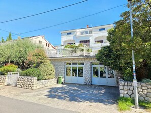 A two-story building with a stone facade, a balcony, and a gated entrance. - Wohnung für 4-5 Personen mit Terrasse by Interhome (Crikvenica/Dramalj)