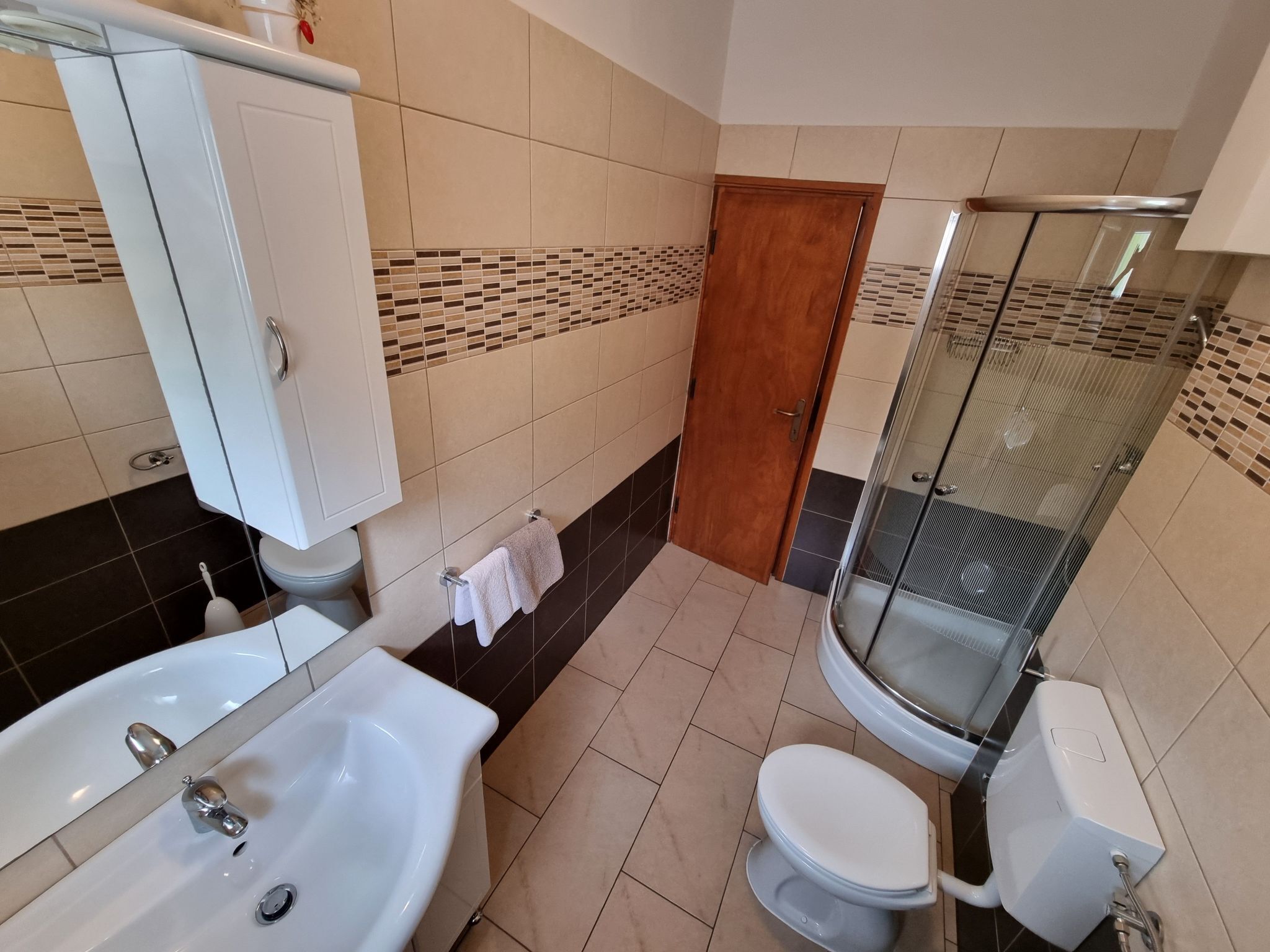 Une salle de bain équipée d’un lavabo, de toilettes et d’une douche.