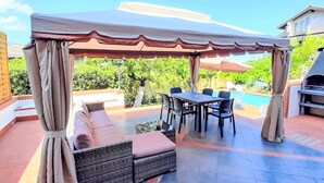An outdoor patio with a covered seating area, a dining table, and a barbecue grill. - Sizilianisches Haus by Interhome (Viagrande)