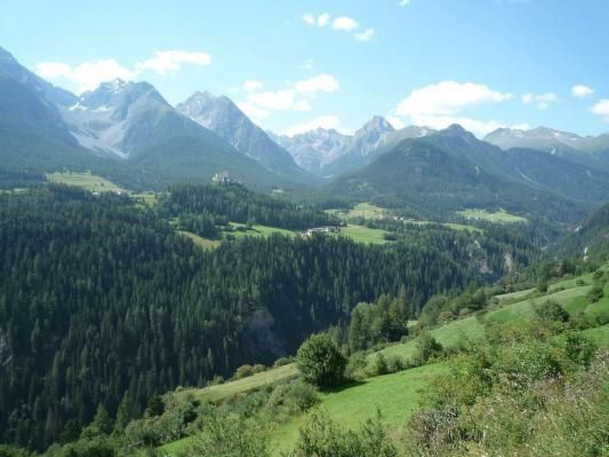 A mountainous landscape with dense forests and a valley.