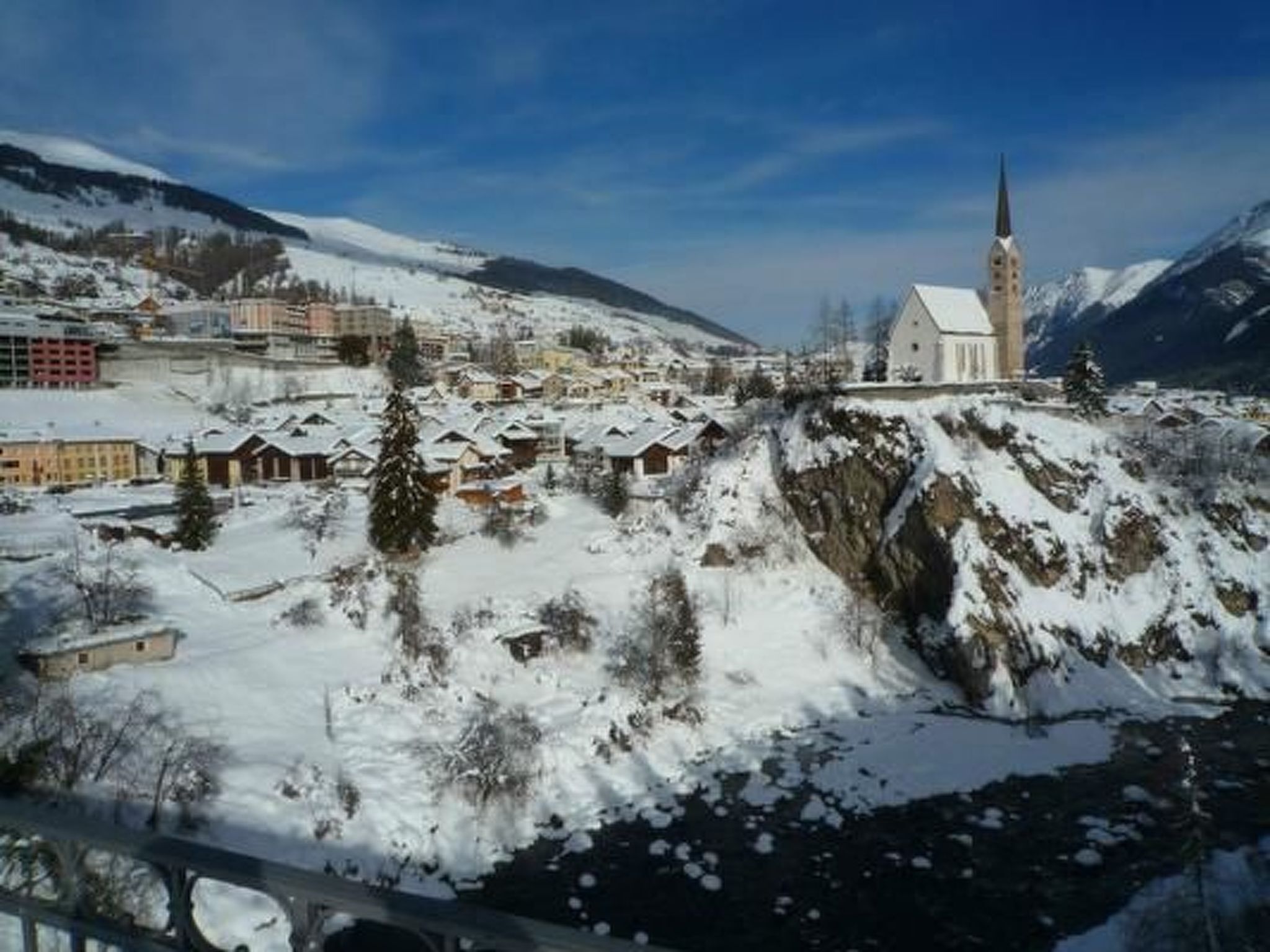 A snow-covered mountain town with a prominent church on a hill.
