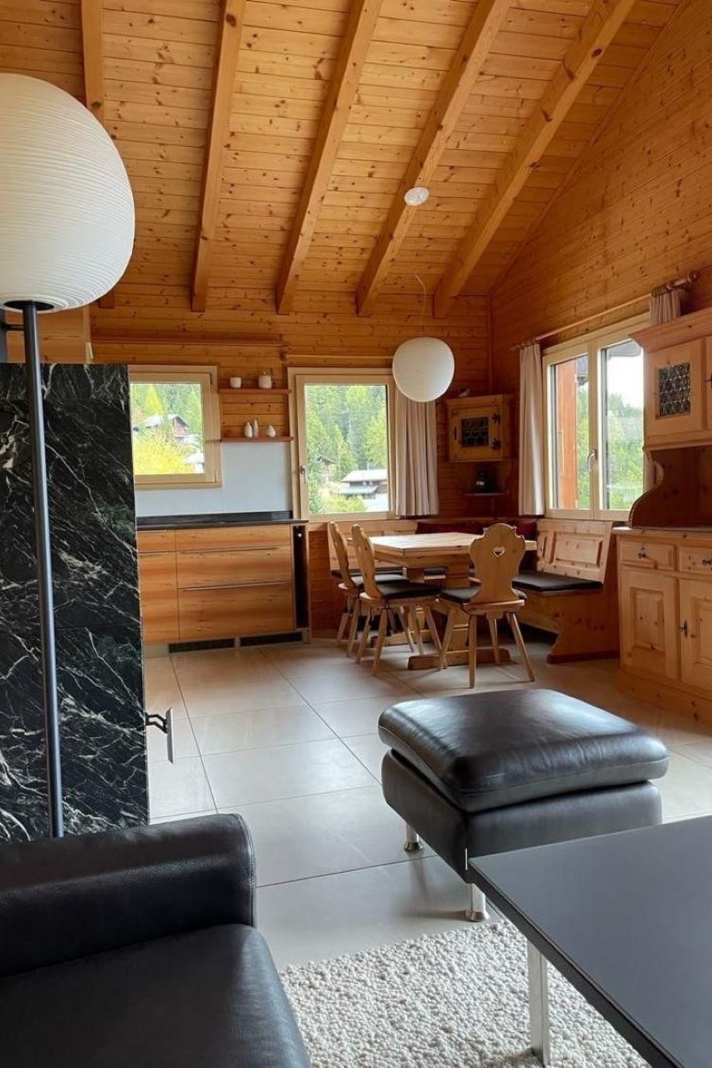 Ein Holzblockhaus-Innenraum mit Essbereich, Küche und Sitzgelegenheiten.