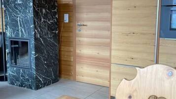Un intérieur en bois avec une cheminée en marbre, une porte en bois et une découpe en forme de cœur sur une table.