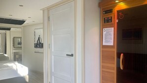 A hotel room with a bed, a white door, a wooden paneling wall, and a small wooden desk with a chair. - Ruhiges Ferienhaus mit großer offener Küche by Interhome (Anjum)