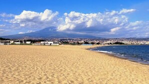 A beach with a clear view of a distant mountain and a cityscape. - Ventimiglia257 by Interhome (Catania)