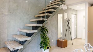 A modern interior with a glass staircase, a potted plant, and a seating area. - "Villa Tango2" mit Blick auf das Wasser by Interhome (Trogir/Okrug Donji)
