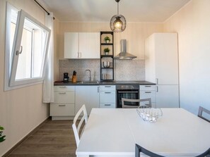Een koelkast, een oven, kookgerei, borden en bestek