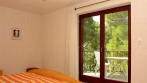 Un dormitorio con cama, ventana y vistas al exterior.
