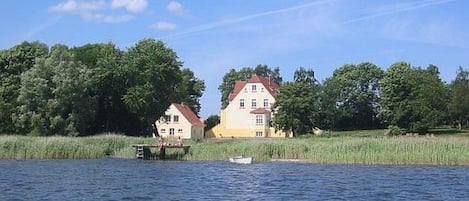 A house by a calm lake with a dock.