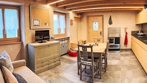 Ein gemütliches Blockhaus-Interieur mit Essbereich, Küche und einer Couch.