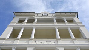 Un edificio con el nombre "Villa Celia" en su fachada, que presenta elementos arquitectónicos clásicos como columnas y arcos.