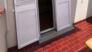A room with a sliding door, a small step leading to the entrance, and a yellow and white striped awning above. - für 3 Personen  + 1 Kind ca. 68 m² in Žaboric, Dalmatien (Gespanschaft Sib by Interhome (Brodarica/Žaborić)