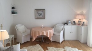 A cozy room with a round table, two chairs, a cabinet, and a framed picture on the wall. - Chesa Lodola by Interhome (Madulain)