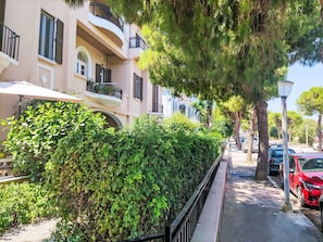A row of residential buildings with balconies, a sidewalk, parked cars, and trees. - Wohnung mit Meerblick und großer Terrasse by Interhome (Faliraki)